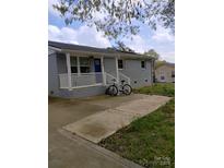 Charming exterior view of the home with a blue door, white porch, and bicycle parked out front at 1204 Borders Rd, Shelby, NC 28150