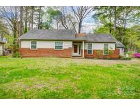 Charming single-story home featuring a brick foundation and well-manicured front lawn at 1212 Robinhood Cir, Charlotte, NC 28227