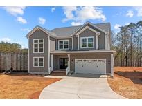 Charming two-story home with gray siding, white trim, covered entrance, and an attached two-car garage at 143 Mills Garden Rd, Statesville, NC 28625