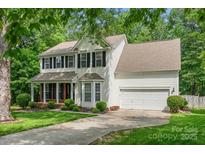 Charming two-story home with black shutters, brick accents and a lush green lawn at 15001 Arrowgrass Way, Charlotte, NC 28278