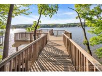 Picturesque view along a wooden dock leading to a deck overlooking the serene lake at 338 Fairfield Ct, Mount Gilead, NC 27306