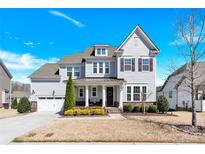 Beautiful two-story home with a well-manicured lawn and attached two-car garage on a sunny day at 345 Somerled Way, Waxhaw, NC 28173