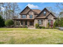 Charming two-story brick home with a well-manicured lawn and inviting covered front porch at 4231 Brushy Knl, York, SC 29745