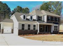 Charming two-story home with a brick facade, attached garage and well-manicured lawn at 7005 New Town Rd, Waxhaw, NC 28173