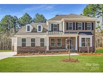 Stunning two-story home featuring brick and siding exterior with dormer windows and professionally landscaped yard at 7005 New Town Rd, Waxhaw, NC 28173