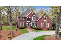 Beautiful brick home with manicured lawn, mature trees, and a winding driveway leading to a stately entrance at 101 Saddletree Rd, Lincolnton, NC 28092