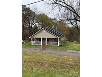 Charming single-story home featuring a welcoming porch, neutral siding, and a contrasting black roof at 1336 Mt Sinai Church Rd, Shelby, NC 28152