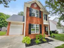 Charming two-story brick home featuring a well-manicured front yard and attached garage at 15188 Eric Kyle Dr, Huntersville, NC 28078