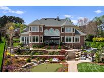 Expansive backyard with stone terracing, putting green, and an outdoor living area, perfect for entertaining at 3988 Channel Point Ln, Denver, NC 28037