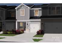 Charming two-story townhome featuring a modern design, white garage door, and low maintenance landscaping at 4325 Summit Woods Dr, Charlotte, NC 28216