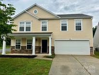 Charming two-story home featuring a covered front porch, stone accents, and a two-car garage at 4418 Palustris Ct, Charlotte, NC 28269