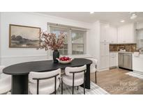 Bright dining room with modern oval table, decor, and stylish chairs next to a window at 5329 Glenbrier Dr, Charlotte, NC 28212