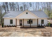 Charming home featuring a covered porch with wood columns and a well-maintained front yard at 676 Chapel Hill Dr, Troy, NC 27371