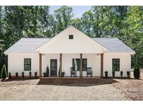 Charming home features a welcoming front porch with rocking chairs and a well-maintained yard at 676 Chapel Hill Dr, Troy, NC 27371