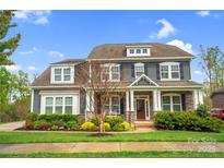 Charming two-story home featuring stone accents and a well-manicured lawn at 13713 Sunset Bluffs Cir, Huntersville, NC 28078