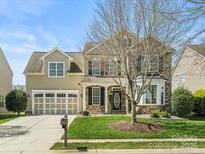 Charming two-story home with a manicured lawn, two-car garage, and stone accents on the facade at 1528 Ridge Haven Rd, Waxhaw, NC 28173