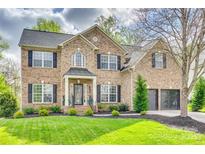 Stunning brick home with a lush green lawn, manicured landscaping, and a two-car garage at 1813 Robbins Meadows Dr, Waxhaw, NC 28173