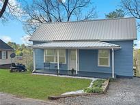 Charming light blue home featuring a metal roof and inviting covered front porch at 2210 22Nd Avenue Se Ct, Hickory, NC 28602