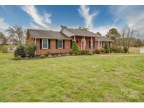 Charming single-story brick home featuring a well-kept lawn and beautiful landscaping at 24436 Nc 24/27 Hwy, Albemarle, NC 28001