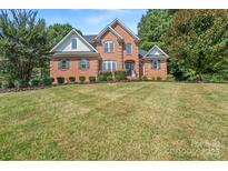 Charming brick home featuring a well-manicured lawn and mature landscaping at 255 Honeysuckle Creek Loop, Mooresville, NC 28117