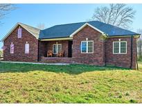 Inviting brick home with rocking chairs on the porch, perfect for relaxing outdoors at 28926 Hartsell Rd, Albemarle, NC 28001