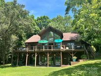 Charming waterfront home featuring a spacious deck, large windows, and a beautiful, wooded lot at 307 Stillwater Rd, Troutman, NC 28166