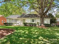 Charming single-story home with a lush, green lawn and mature trees offering shade at 3911 Kitley Pl, Charlotte, NC 28210