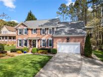 Traditional brick two-story home with a well-manicured lawn, charming shutters, and an attached two-car garage at 4098 Kiser Cove Ln, Terrell, NC 28682