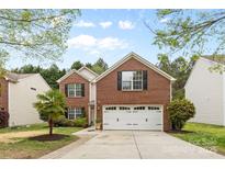 Traditional two-story brick home featuring a well-manicured lawn and an attached two-car garage at 512 Red Oak Ct, Tega Cay, SC 29708