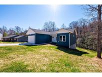 Inviting blue home with white trim, set on a lush green lawn in a tranquil, wooded neighborhood at 1314 39Th Street Sw Cir, Hickory, NC 28602