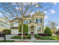 Charming two-story home with well-maintained landscaping, mature trees, and inviting entrance at 15402 Country Lake Dr, Pineville, NC 28134