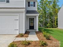 Close-up of the front entrance featuring a black door, manicured landscaping, and a welcoming porch at 3034 Trailblazer St, Charlotte, NC 28215