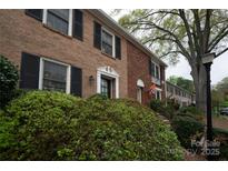 Brick townhome featuring dark shutters, tasteful landscaping, and classic architectural elements, offering a blend of charm and curb appeal at 4609 Hedgemore Dr # I, Charlotte, NC 28209