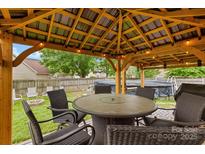 Relax in this backyard gazebo with a fire pit and an above ground swimming pool at 5519 Burning Ridge Dr, Monroe, NC 28110
