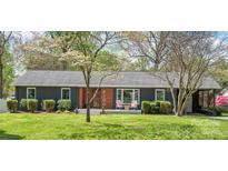 Charming single-story home with mature landscaping, a modern facade, and an inviting front porch at 6100 Rose Valley Dr, Charlotte, NC 28210