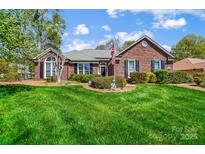 Charming brick home with manicured lawn and mature landscaping, creating inviting curb appeal at 6420 Conifer Cir, Indian Trail, NC 28079
