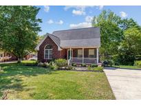 Charming brick home with a well-manicured lawn, a white picket fence, and beautiful landscaping at 1008 Autumn Ln, Concord, NC 28025