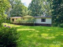 Ranch style home featuring a long front porch and well-maintained yard surrounded by lush trees at 1031 Lester Trl, Iron Station, NC 28080