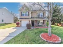 Charming two-story home with a stone accent front, well-manicured lawn, and inviting front porch at 1135 Valley St, Statesville, NC 28677