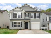 Charming two-story home with gray siding, black shutters, a well-kept lawn, and attached garage at 2005 Dunsmore Ln, Waxhaw, NC 28173