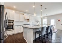 Bright kitchen boasts white cabinets, granite counters, and stainless steel appliances at 2052 Donaldson St, Indian Land, SC 29707