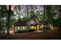 Stunning two-story home with a beautifully landscaped yard surrounded by mature trees and waterfront access at 252 Greyfriars Rd, Mooresville, NC 28117