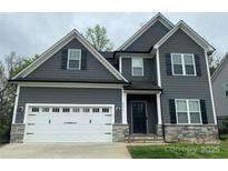Charming two-story home with gray siding, white trim, and a two-car garage at 2676 Poplar Cove Nw Dr, Concord, NC 28027