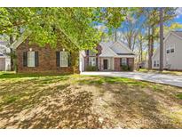 Charming brick home featuring a well-maintained lawn and a long driveway at 3002 Enderbury Dr, Indian Trail, NC 28079