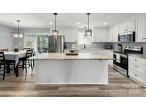 Bright kitchen featuring a large island, stainless steel appliances, and modern pendant lighting at 3018 Corinth Church Rd, Monroe, NC 28112