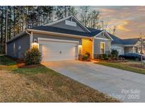 Charming home featuring a two-car garage, manicured lawn, and inviting exterior lighting at 4427 Bright Rd, Charlotte, NC 28214