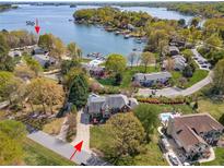 Stunning aerial view of a waterfront property with mature trees, private boat slip, and neighborhood pool at 7980 Bradford Ln, Denver, NC 28037