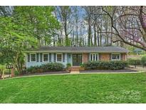 Charming single story home with manicured lawn, mature trees, and inviting front entrance at 9025 Shields Dr, Huntersville, NC 28078