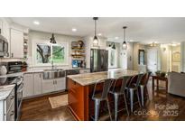 Beautiful kitchen features stainless appliances, island with barstool seating and a view out of a bright window at 9025 Shields Dr, Huntersville, NC 28078