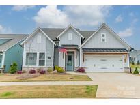 Charming home featuring a craftsman style elevation, two-car garage, a well-manicured lawn, and patriotic decor at 1402 Encore Ln, Waxhaw, NC 28173